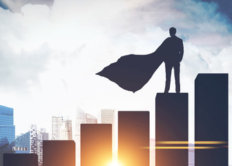 Superman businessman silhouette on bar chart, city