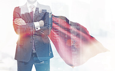 Confident businessman in a red cape, city
