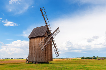 Fototapeta na wymiar Old wooden windmill on field in summer day. Poland