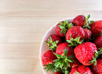 Cup of strawberries on wooden background