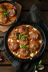 Meatballs with tomato sauce on black skillet