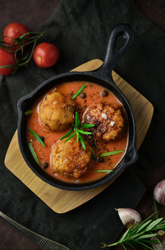 Meatballs with tomato sauce on black skillet