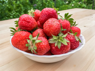 Cup of strawberries on wooden background