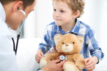 Doctor and child patient. Physician examines little boy by stethoscope. Medicine and children's therapy concept