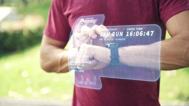 Man using high tech smart watch in park. Young white man accessing his smart watch with holographic display special effects overlay panel for other use. Future technology concept. - Powered by Adobe