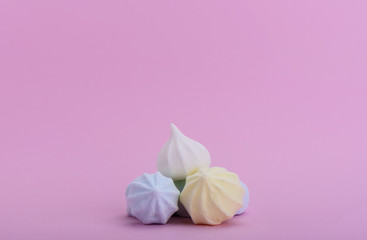 Pyramid of multicolored meringues on a pink background