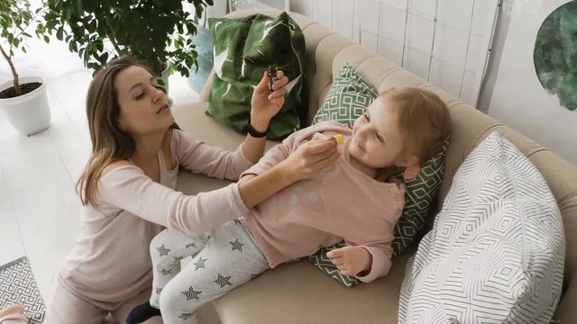 Mother dripping medicines in daughter's nose