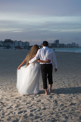 Married couple walking on the beach