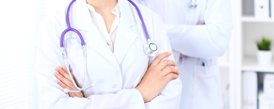 Unknown female doctor with medical staff  at hospital. Teamwork in medicine