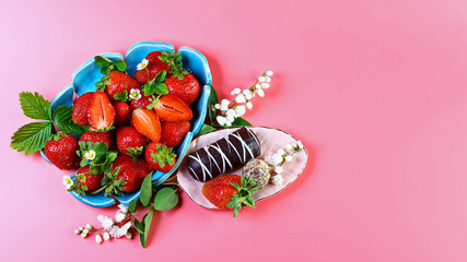 Strawberries with chocolate on a decorative ceramic plate, isolated on a pink background. Flat lay....