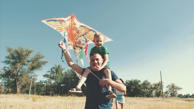 Happy family, mom, dad and son are walking in nature, launching an air snake. Stock footage.