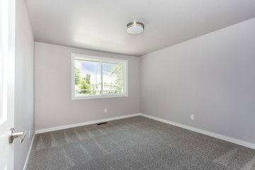 Small empty room with grey carpet floor.