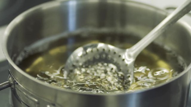 Cook take cutlet from boiling oil with a spatula in slow motion