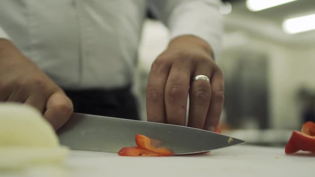 Chef cuts bulgarian pepper into pieces in slow motion