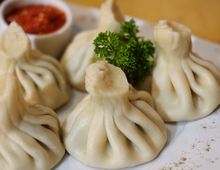 Georgian dumplings Khinkali with meat, greens and tomato spicy sauce.