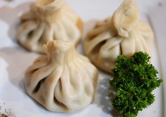 Georgian dumplings Khinkali with meat, greens and tomato spicy sauce.
