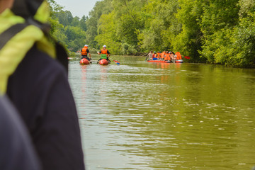 A group of tourists floats on a fresh, calm river on inflatable catamarans, outdoor activities,...