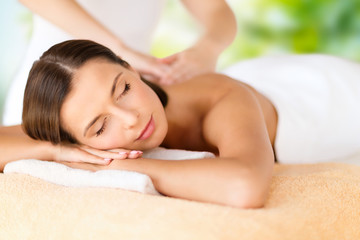 wellness, spa and beauty concept - close up of beautiful woman having massage over green natural background