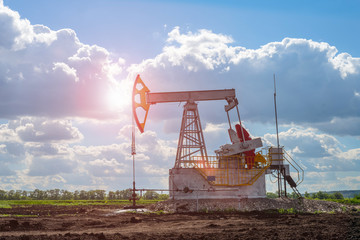 Oil and natural gas production tower in the field with a bright sun glare