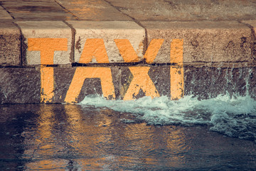 Close up view of yellow taxi boat sign on stone wall near the sea. Opatija, Croatia, Europe.