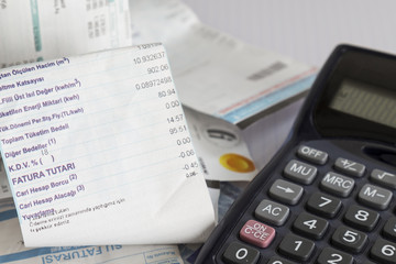 calculator and bills on the white background.the house account does not fit the bazaar.