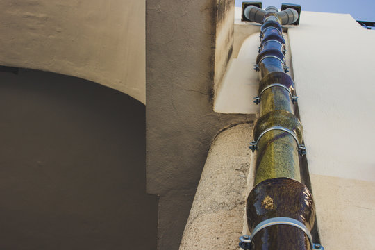 Drain. An unusual ceramic gutter green on a white wall. Mijas, Andalusia, Spain.