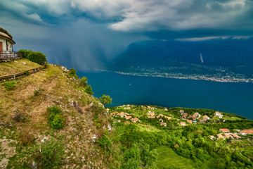 View of the Lake Garda from Tremosine, Italy.Panorama of the gorgeous Garda lake surrounded by mountains in the springtime on a cloudy day and a strong storm