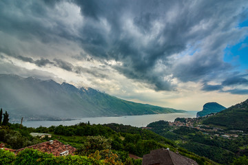 Fototapeta na wymiar View of the Lake Garda from Tremosine, Italy.Panorama of the gorgeous Garda lake surrounded by mountains in the springtime on a cloudy day and a strong storm