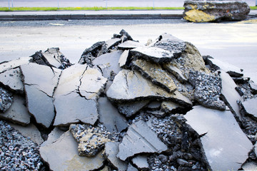 A pile of old asphalt, gravel and sand on the road. 