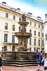 Fototapeta na wymiar Tourists at the second courtyard of Prague Castle (Prazsky hrad) with Kohl Fountain