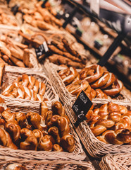 Variety of delicious breads, pizza, buns,pastry, displayed on shelves in Bakery shop.