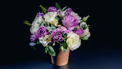 Bouquet of flowers in a coffee cup on a dark blue background. Flower compliment