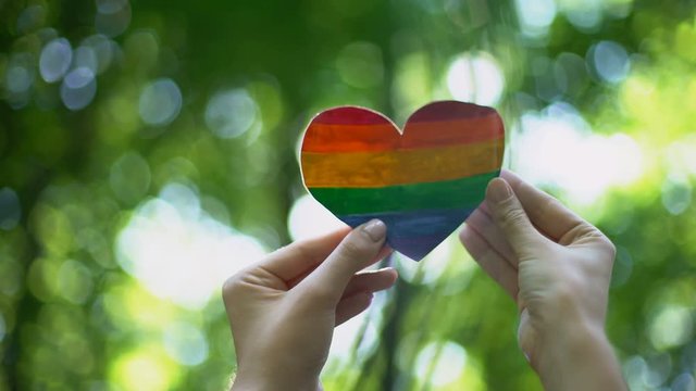 Rainbow heart in female hands, LGBT flag, recognition of sexual minorities right