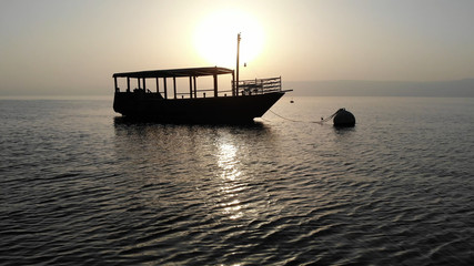 Sun silhouetting a ship on the Sea of Galilee