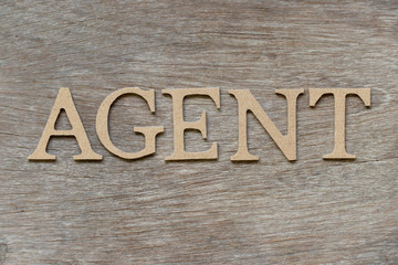 Alphabet letter in word agent on wood background