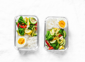 Vegetarian lunch box - stewed vegetables, rice and boiled egg on a light background, top view....