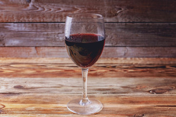 Glass of red wine on a wooden background.