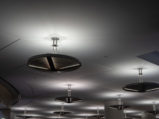 Industrial florescent lights hanging on a modern ceiling 