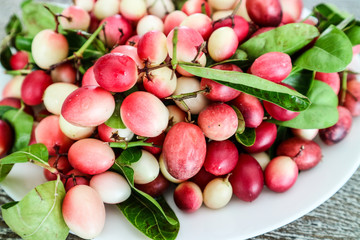 Carunda or Karonda fruit on dish and hard wood background