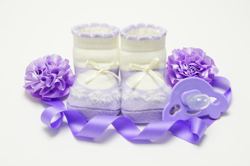 Baby's bootees lilac with pacifier, ribbon and bows.