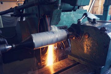 Grinding the shaft on the machine with sparks and cooling, at different angles.