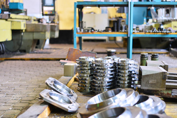 Round iron parts after turning and milling processing are located in the factory.