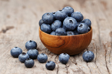 Blueberries in a wood bowl on a wooden table, Healthy eating and nutrition concept