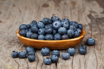 Blueberries in a wood bowl on a wooden table, Healthy eating and nutrition concept