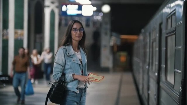 The girl is waiting for the subway train stop, slow motion