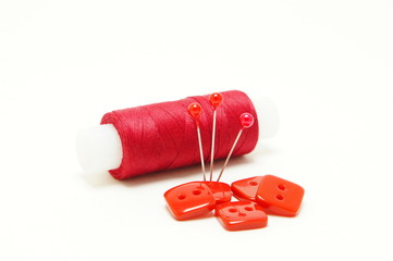Red thread with needles and red buttons.