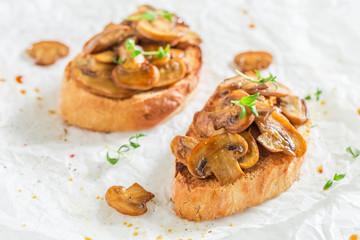 Homemade bruschetta with mushrooms on white table