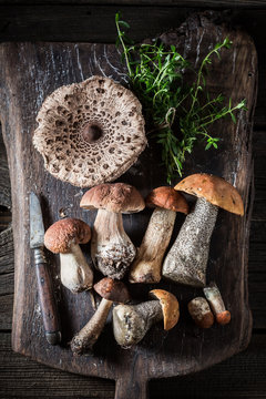 Mix of wild mushrooms and herbs on the old board