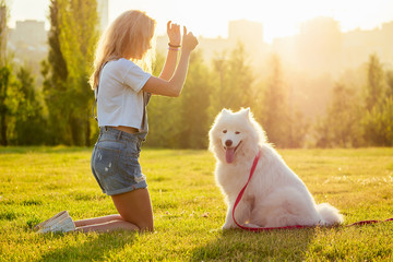 beautiful curly blonde smiling happy young woman in denim shorts are sitting at glass and training...