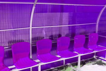 Obraz premium Empty plastic chairs in the stands of the stadium. Many empty seats for spectators in the stands. Empty plastic chairs seats for football fans.